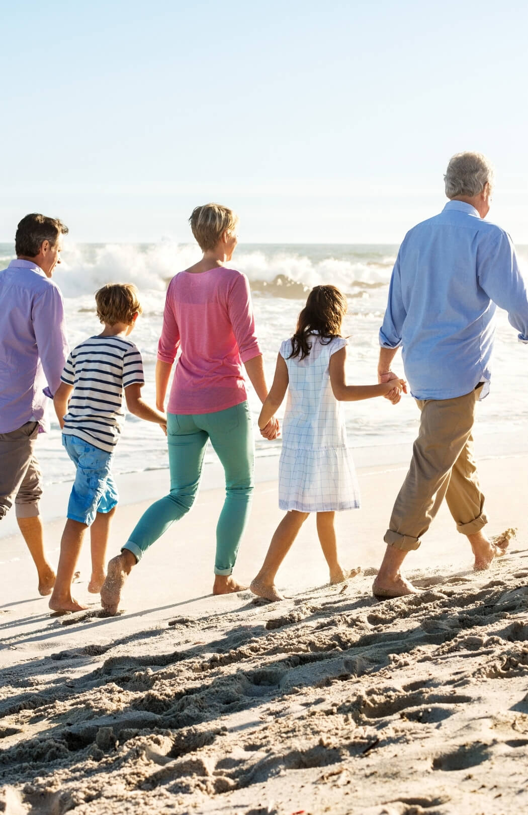 Family Walking Down the Beach, Stress-free Vacation Rental Management so you can enjoy your Oak Island home again